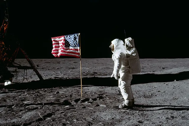 Астронавт Базз Олдрин приветствует американский флаг на поверхности луны