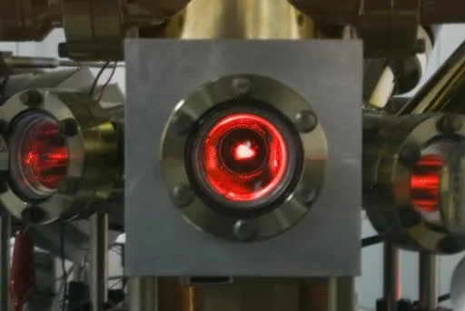 Через окно вакуумной камеры видно светящееся облако атомов при температуре