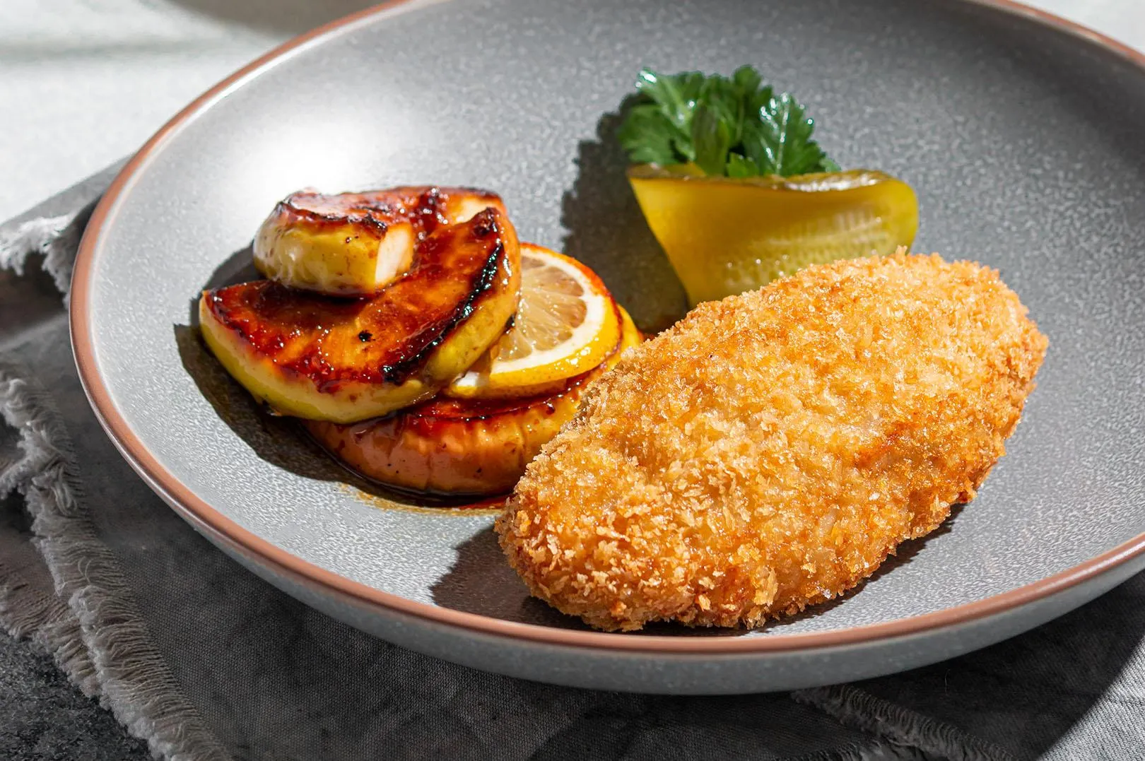 Пожарская котлета изъ «Добрянки» съ жаренымъ яблокомъ и солёнымъ огурцомъ.